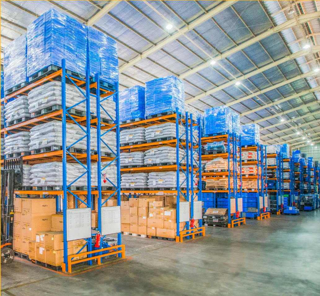 Warehouse with stacked pallets and shelving racks.
