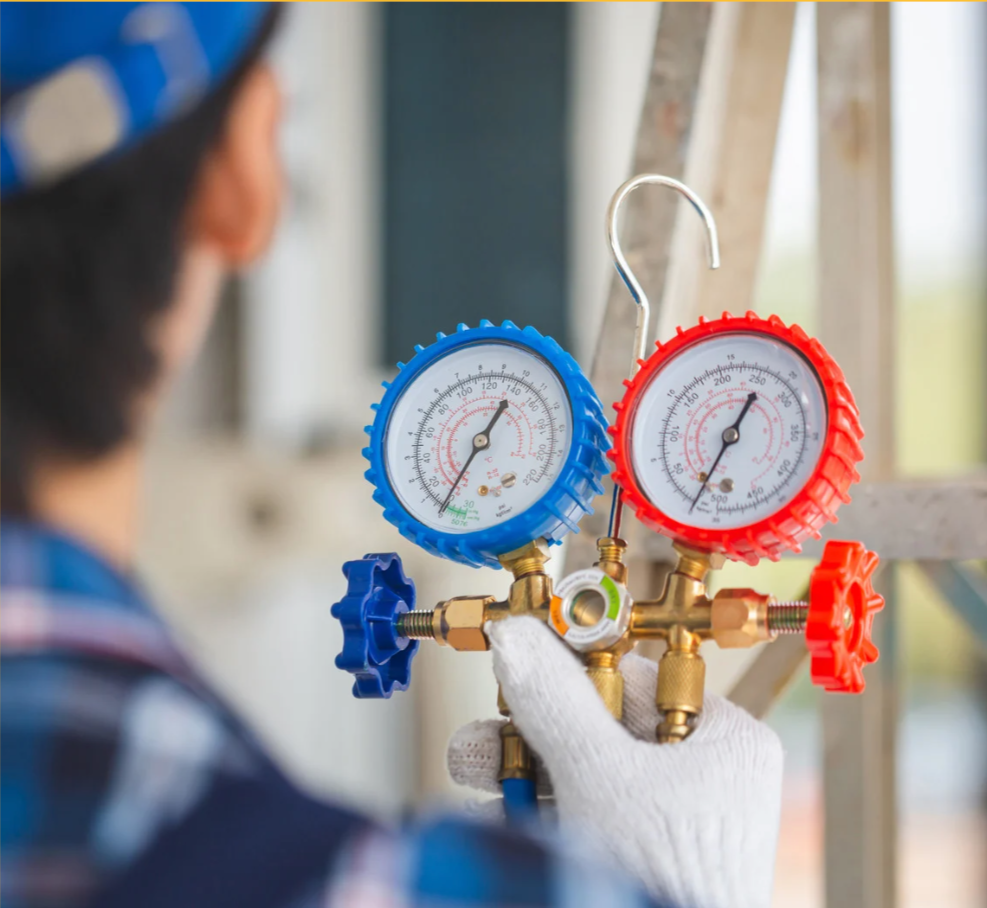 Technician checks HVAC gauges for pressure readings.