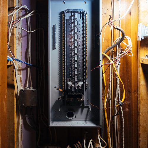 Empty electrical panel with exposed wires